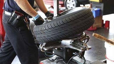 Mechanic Changing Car Tire — Auto Maintenance in McDonough, GA