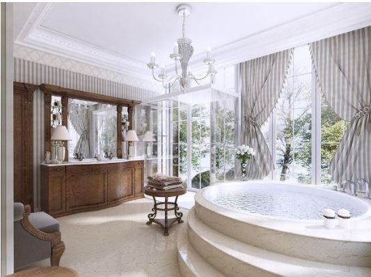 A luxurious bathroom with a large circular tub on a raised stone platform, a wooden vanity, and floor-to-ceiling windows.