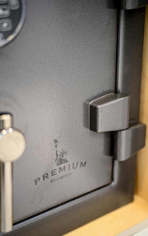 Close-up of a matte black Liberty Premium safe door with a silver handle, digital keypad, and the Liberty brand logo.