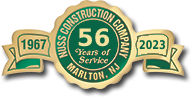 A green and gold circular emblem for Nuss Construction Company in Marlton, NJ, celebrating 56 years from 1967 to 2023.