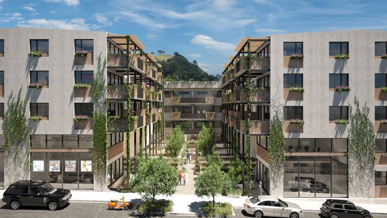 Modern apartment complex with open-air courtyard, trees, balconies, and street-level shops. Cars parked on the street.