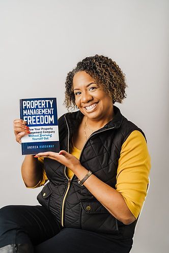 Woman smiling, holding a book titled 