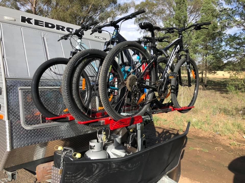 Three Mountain Bikes Mounted on A Red Bike Rack — The Caravan Clinic in South Murwillumbah, NSW