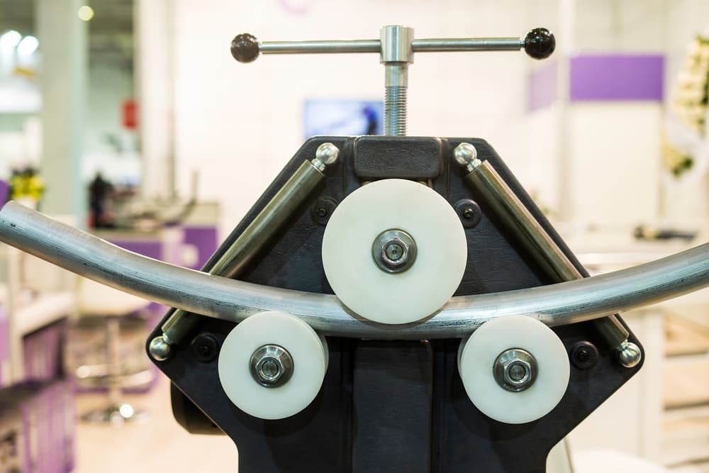 A Close Up Of A Machine That Is Rolling A Metal Pipe - Gold Coast Laser And Pipe Bending in Mudgeeraba, QLD