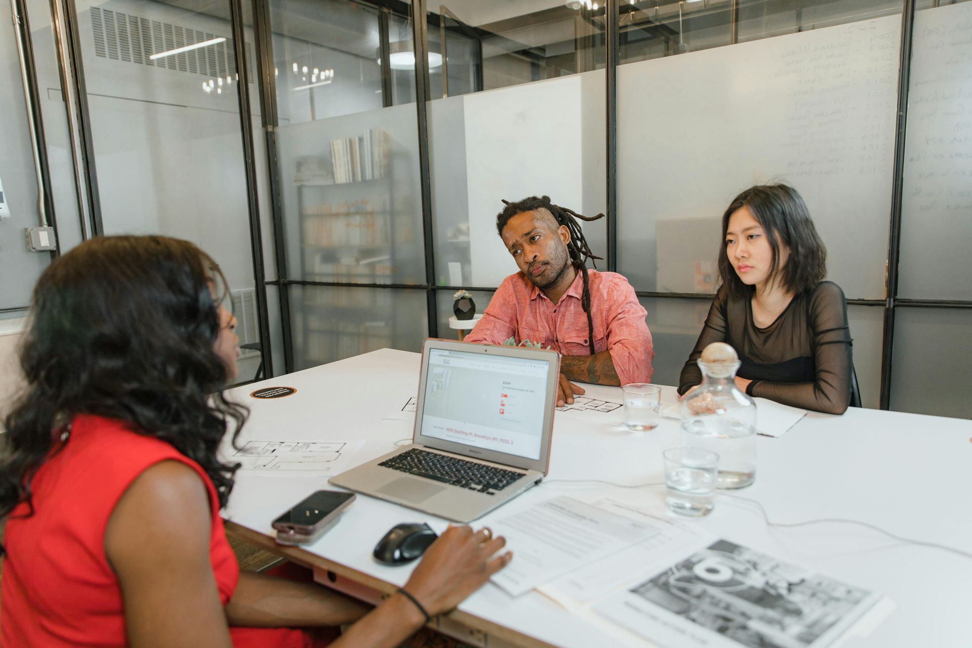 A group of people are sitting at a table with a laptop.