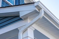 A close up of a white gutter on the side of a house.