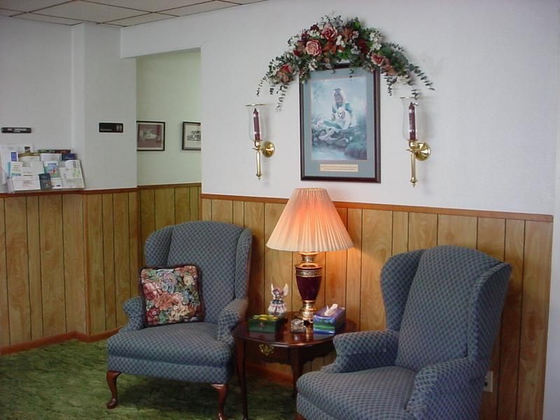 two chairs and a lamp in a room with wood paneling