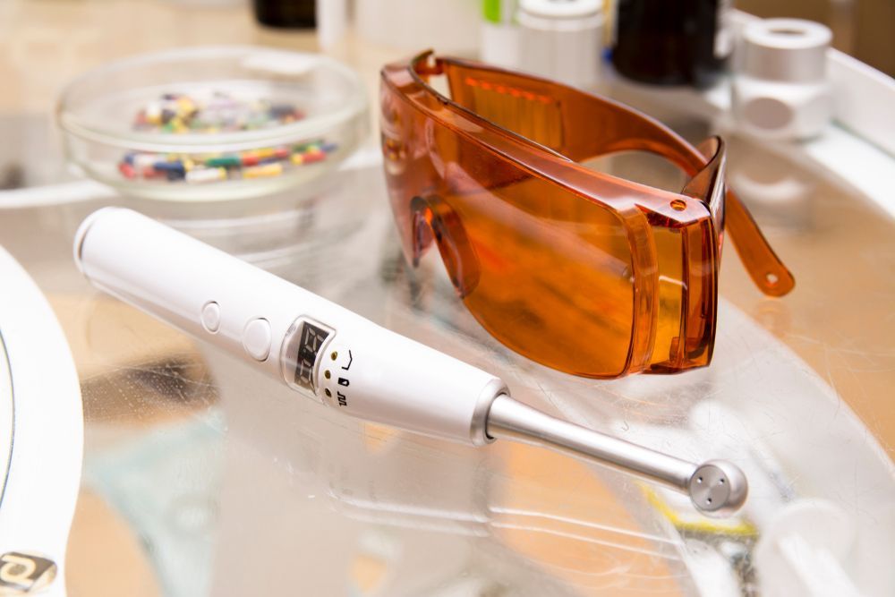 A pair of glasses and a toothbrush are on a table.