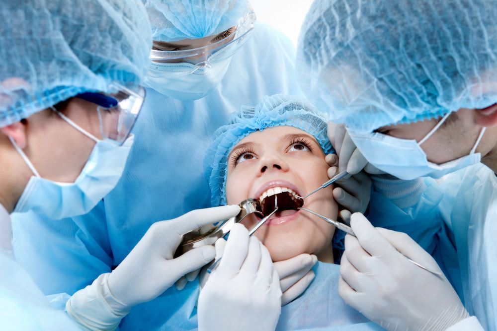A woman is getting her teeth examined by a group of dentists