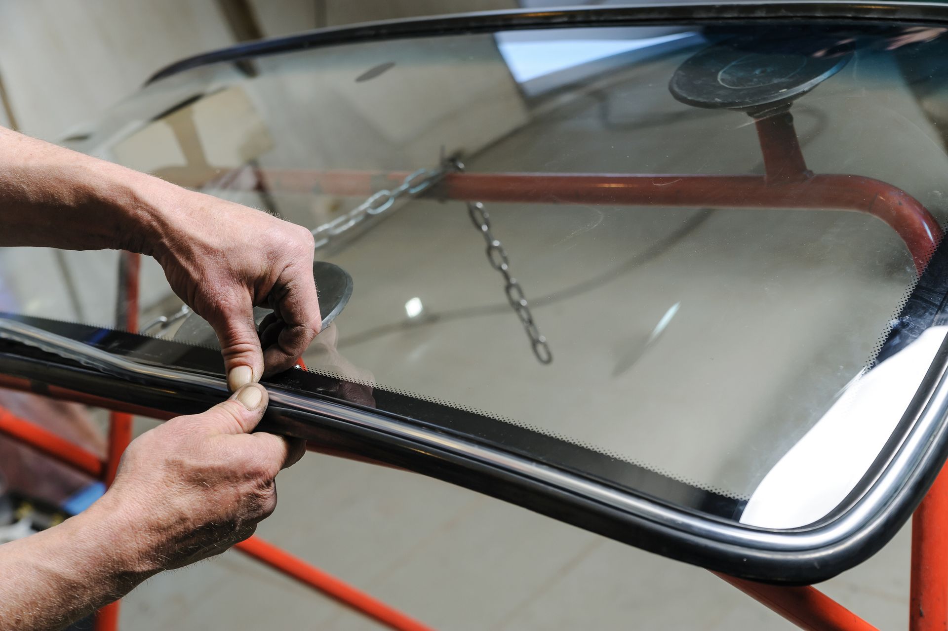 A person is installing a windshield on a car.