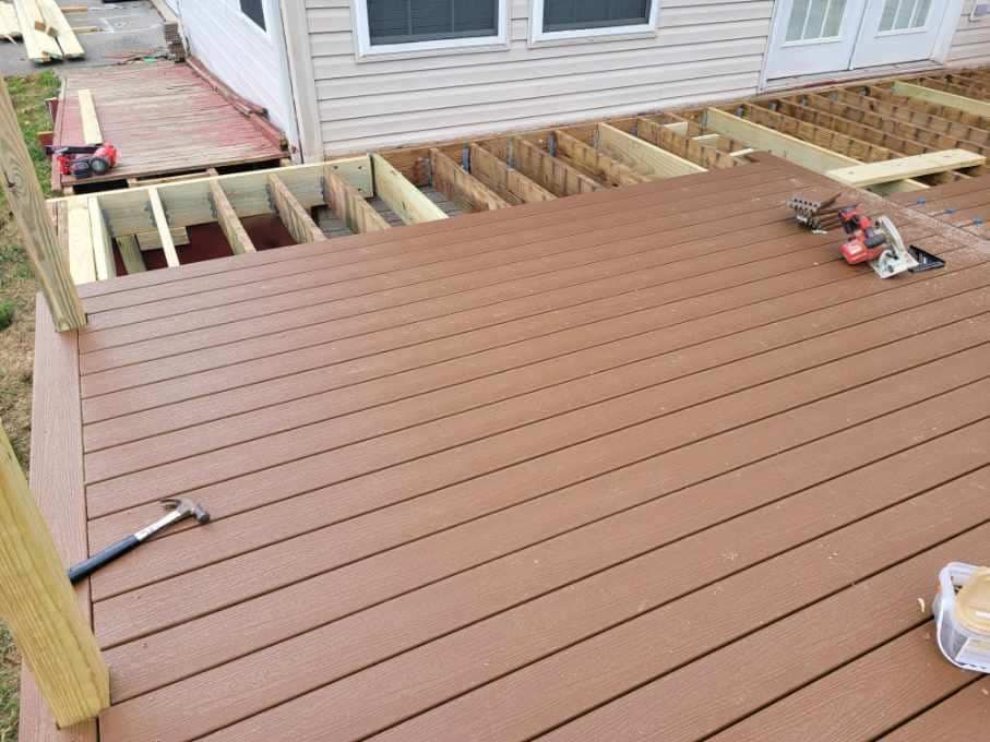 Brown composite deck under construction, with exposed framing and tools.