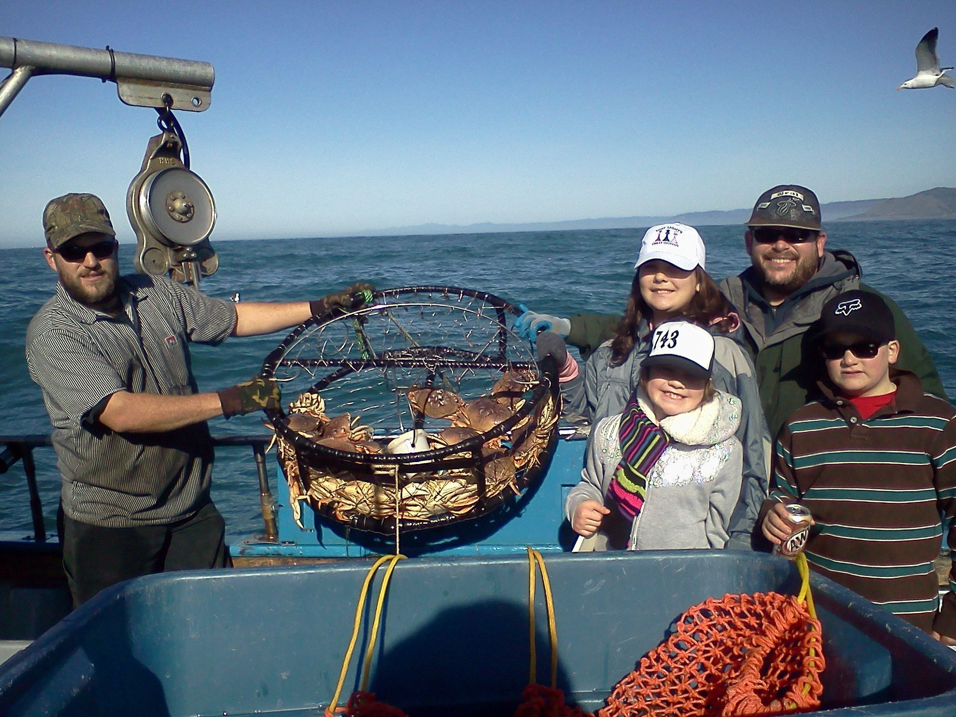 A group of people on a boat with one wearing a ny hat