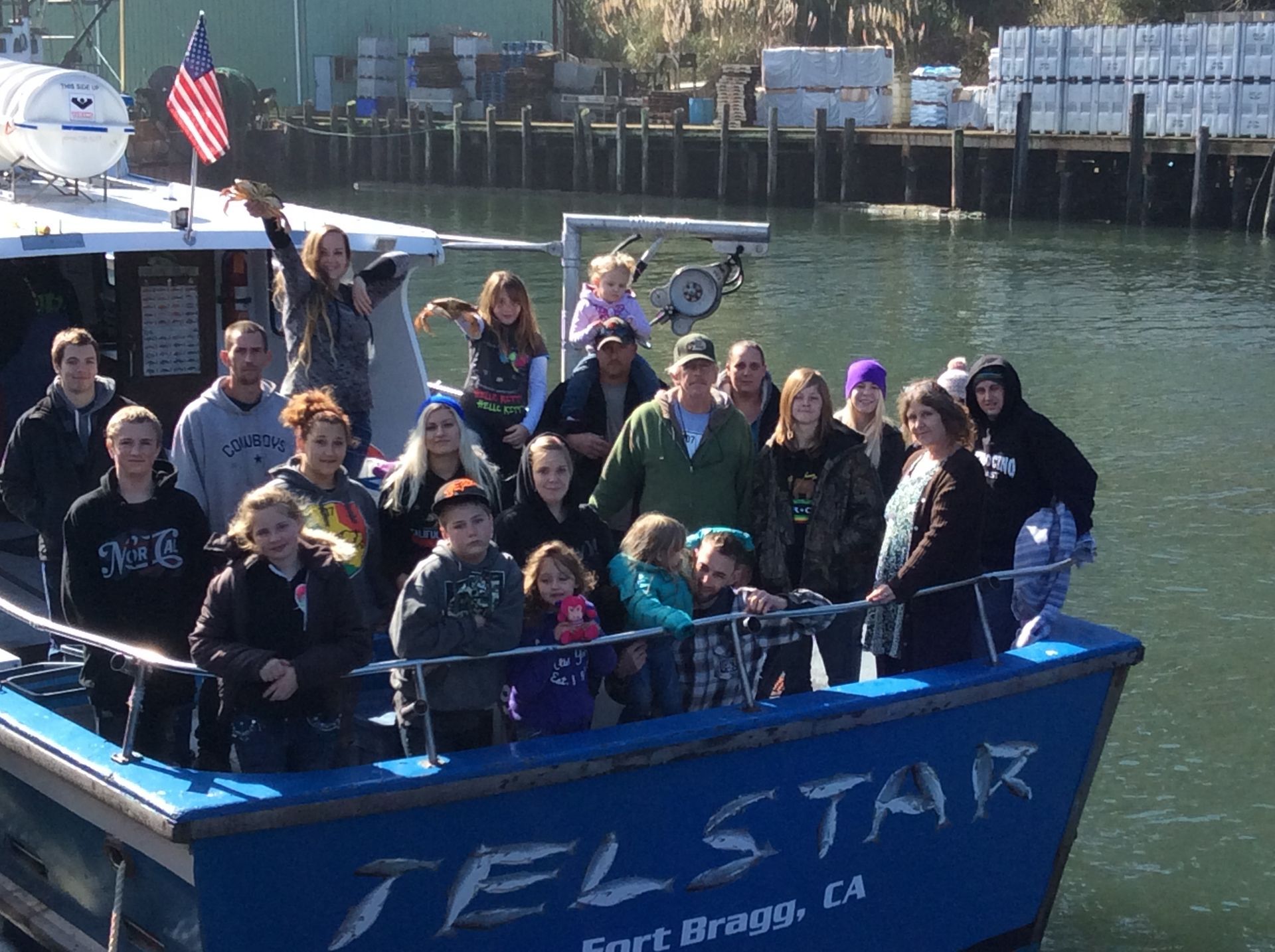 A group of people are standing on a boat that says telstar