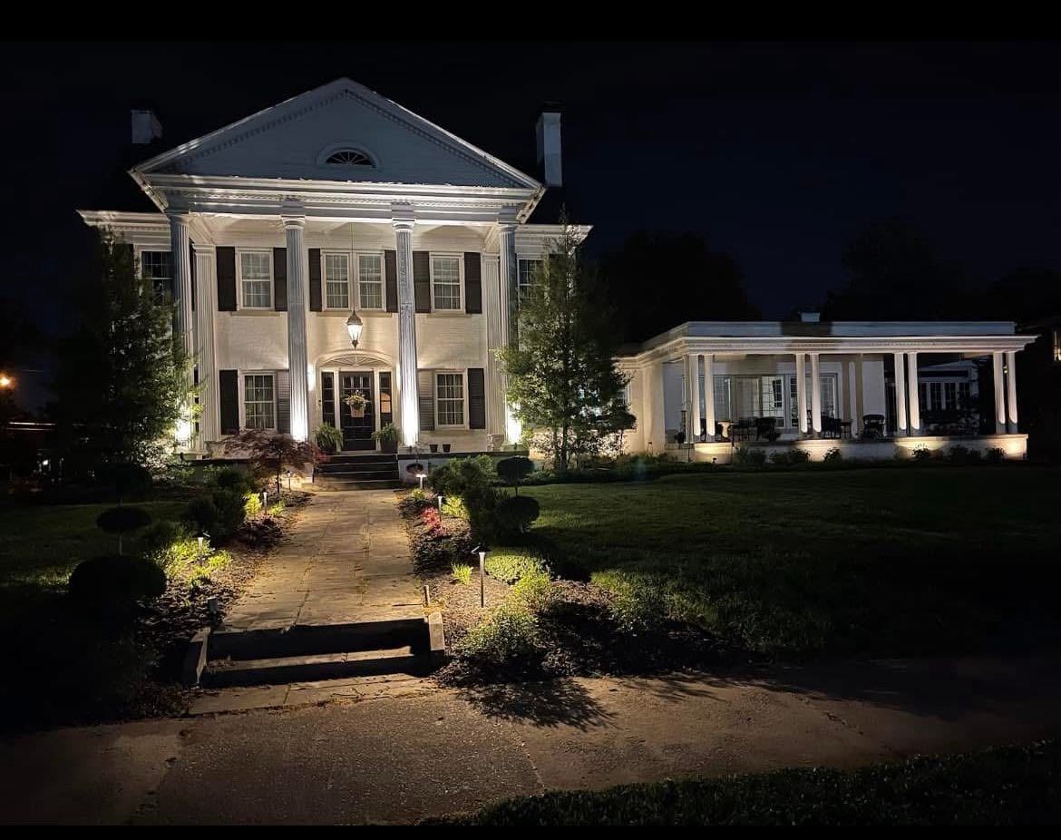 Wooden deck overlooking a lush green forest; lounge chair and grill visible.