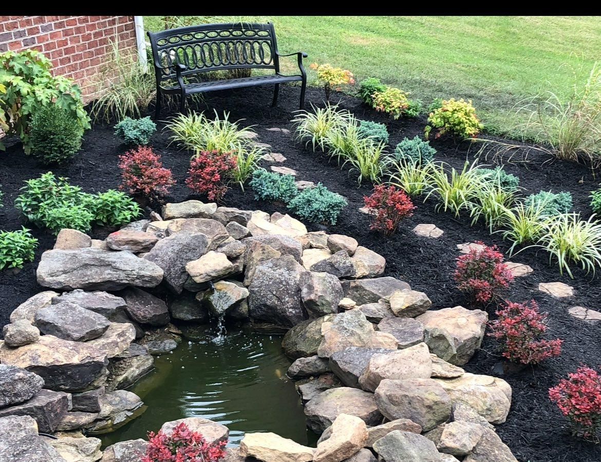 Small blue cottage with a gable roof, brown doors, and stone pathway surrounded by trees.