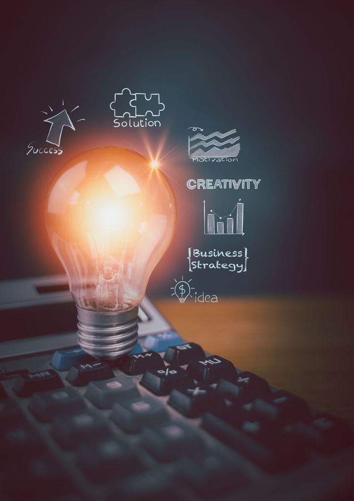 A light bulb is sitting on top of a laptop keyboard.