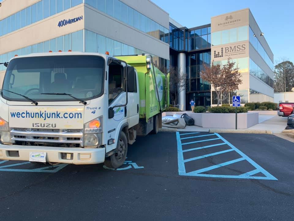 A garbage truck is parked in front of a building.