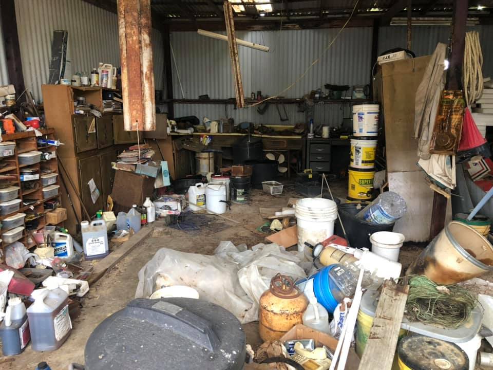 A messy garage filled with lots of junk and buckets.