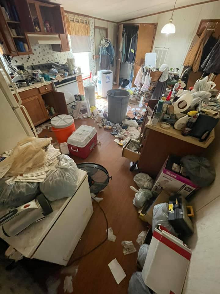A messy room with a lot of trash on the floor.