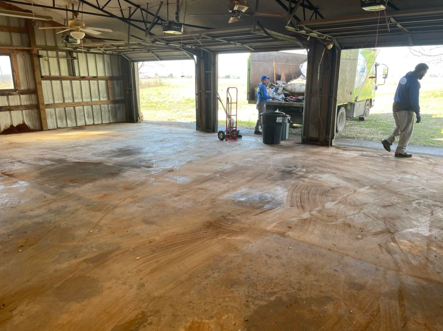 A man is standing in a garage next to a truck.
