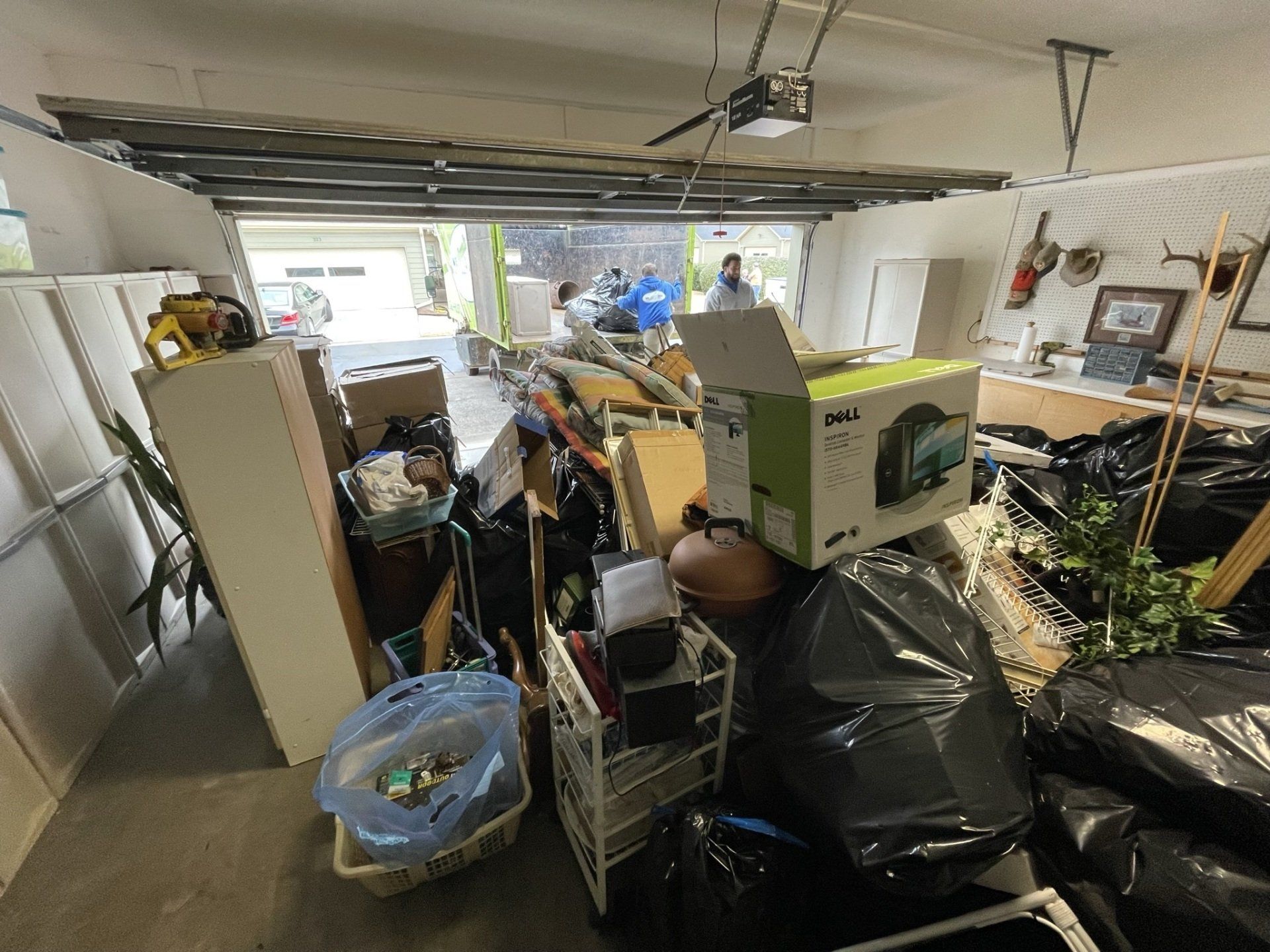 A garage filled with lots of boxes and trash bags.