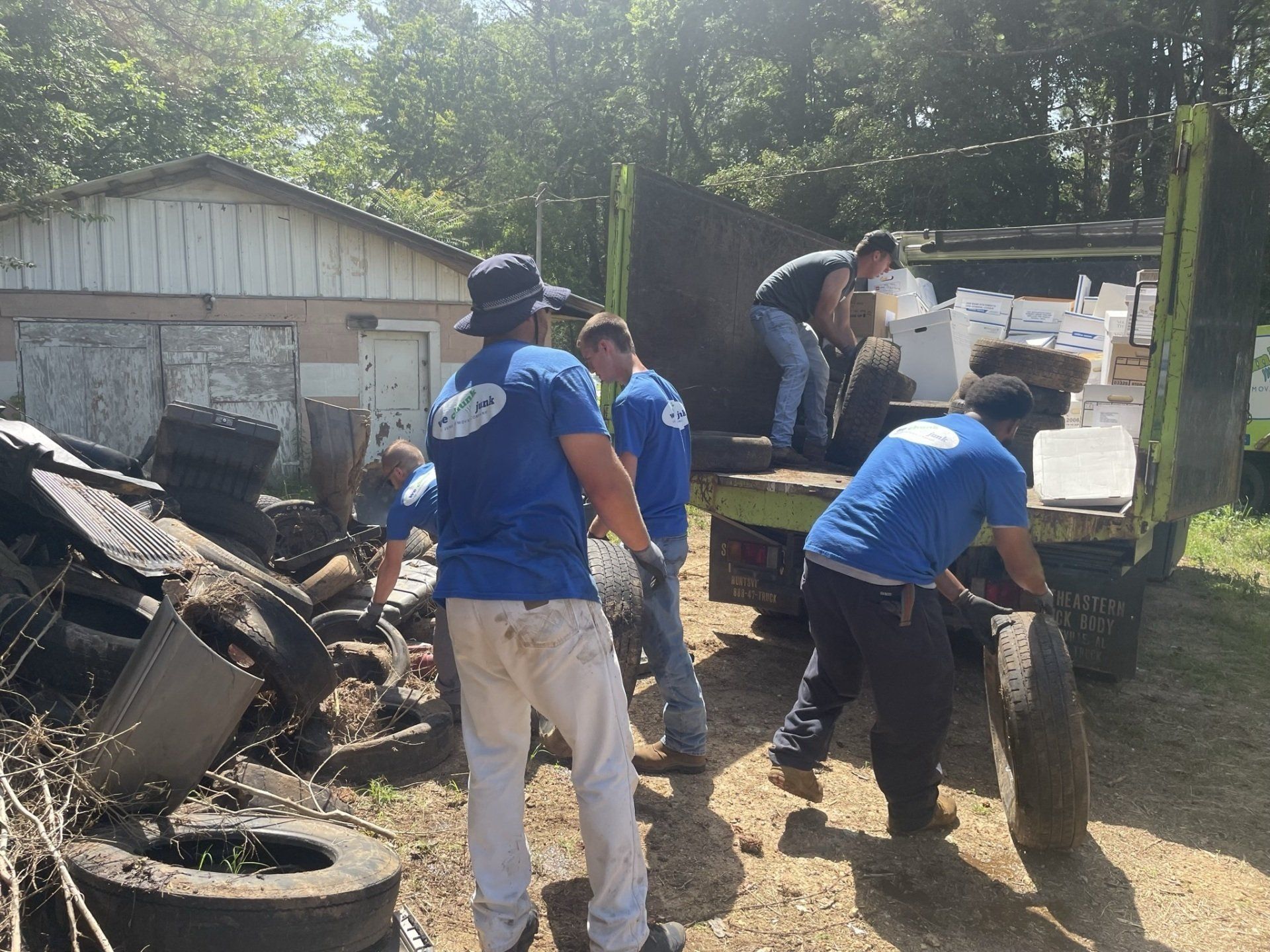 A group of men in blue shirts are working on a truck