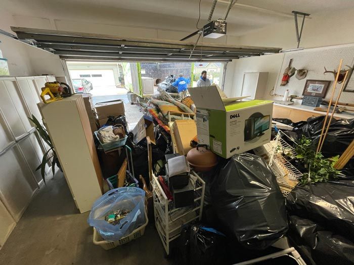 A garage filled with lots of boxes and trash bags.