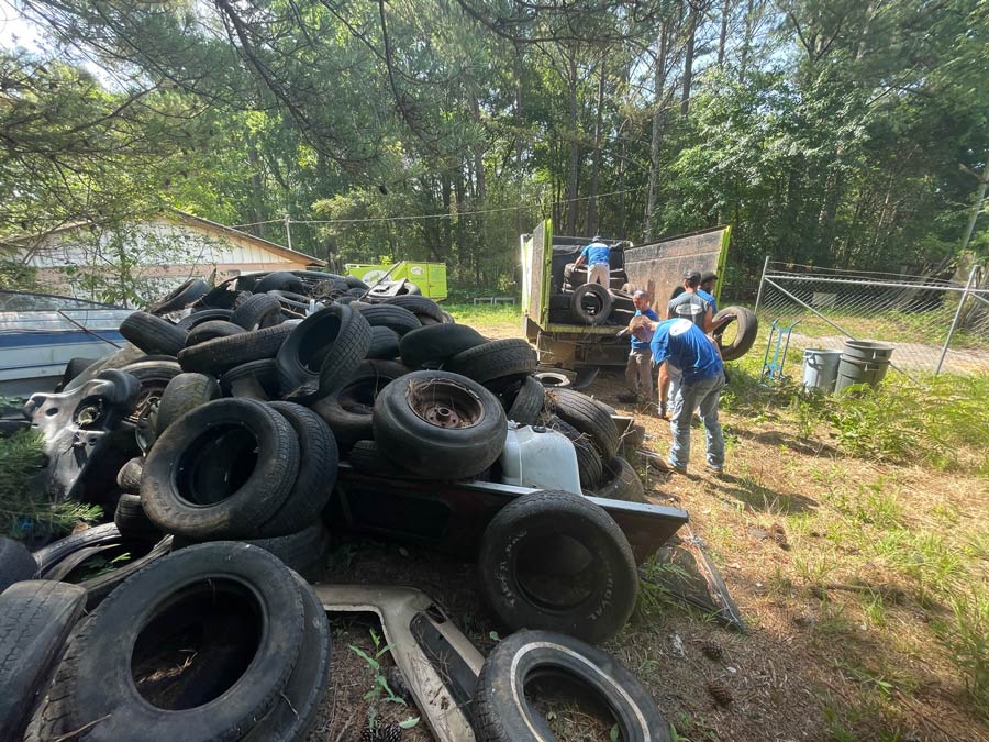 A group of people are standing around a pile of tires.