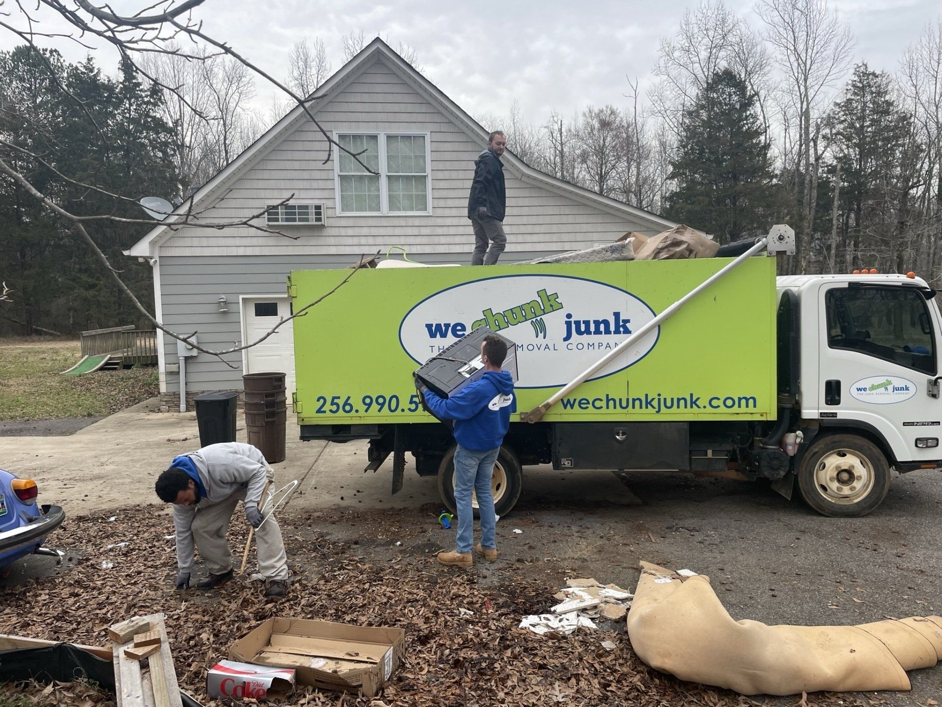 A junk truck is parked in front of a house
