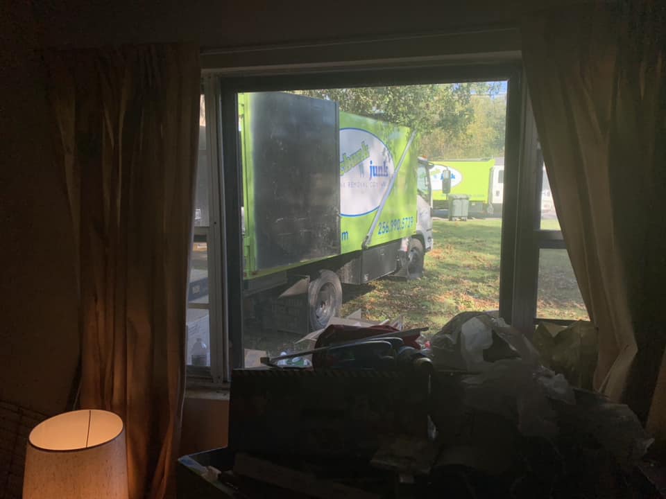 A truck is parked in front of a window in a living room.