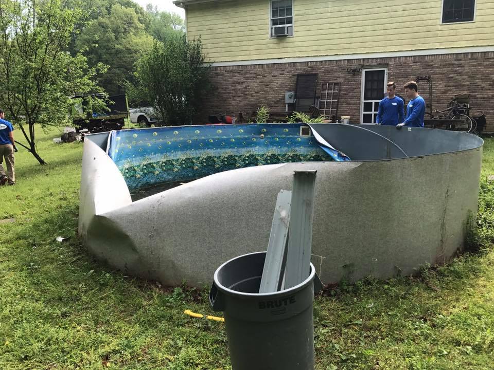 A swimming pool is being built in the backyard of a house.