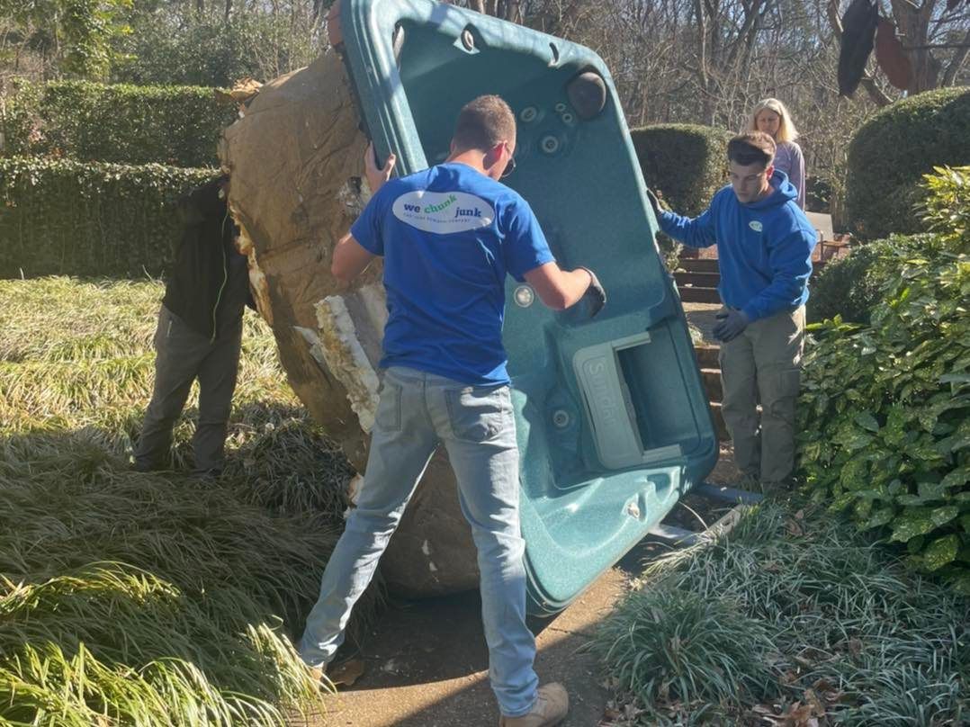 A man in a blue shirt is carrying a large green object