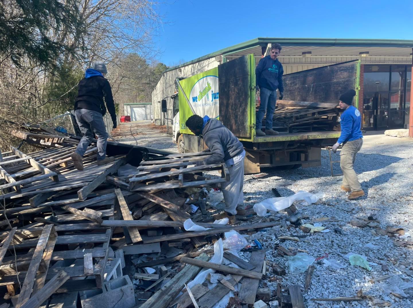 A group of people are working on a pile of wood.
