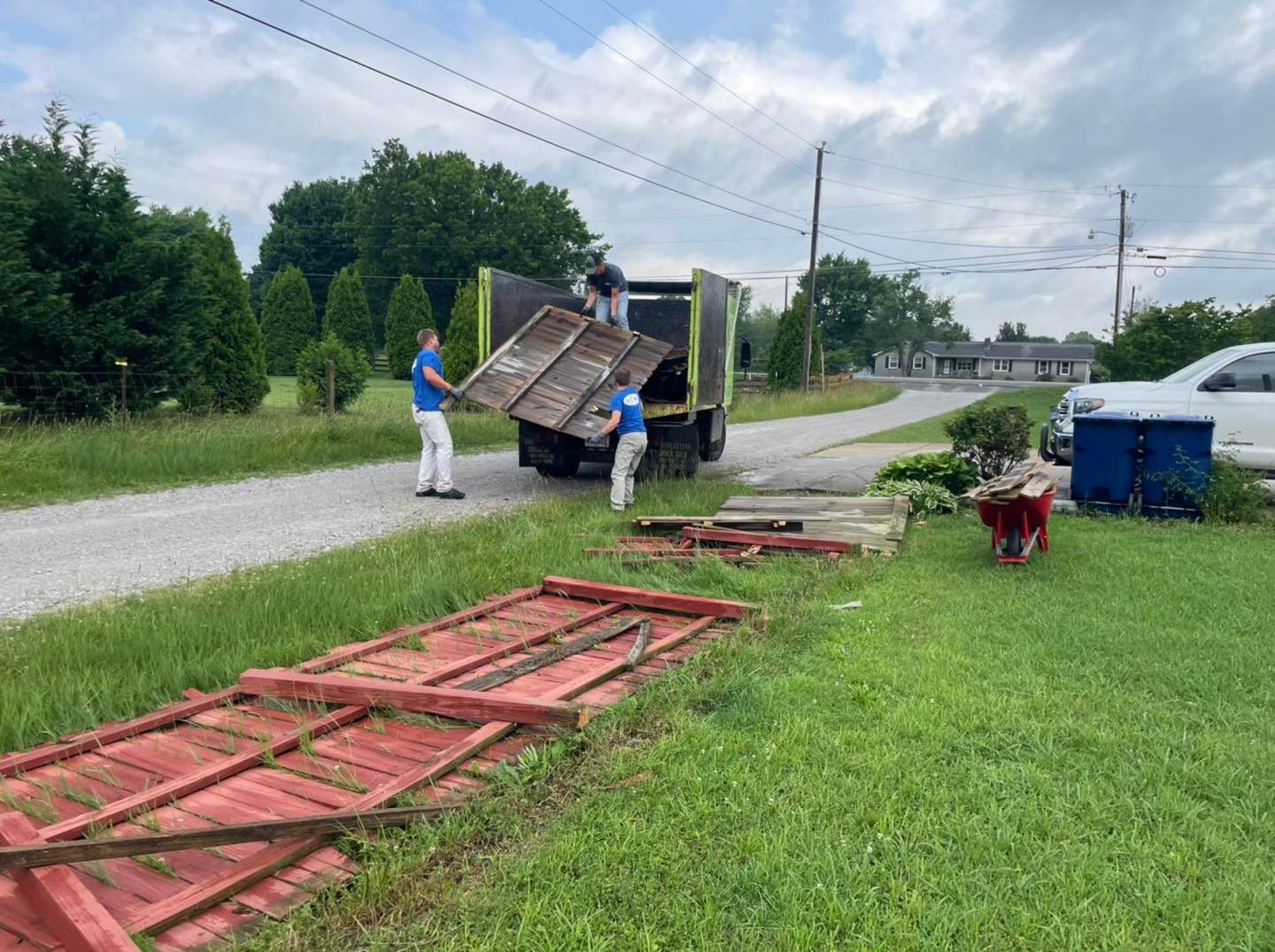 A group of people are loading wooden pallets into a truck.