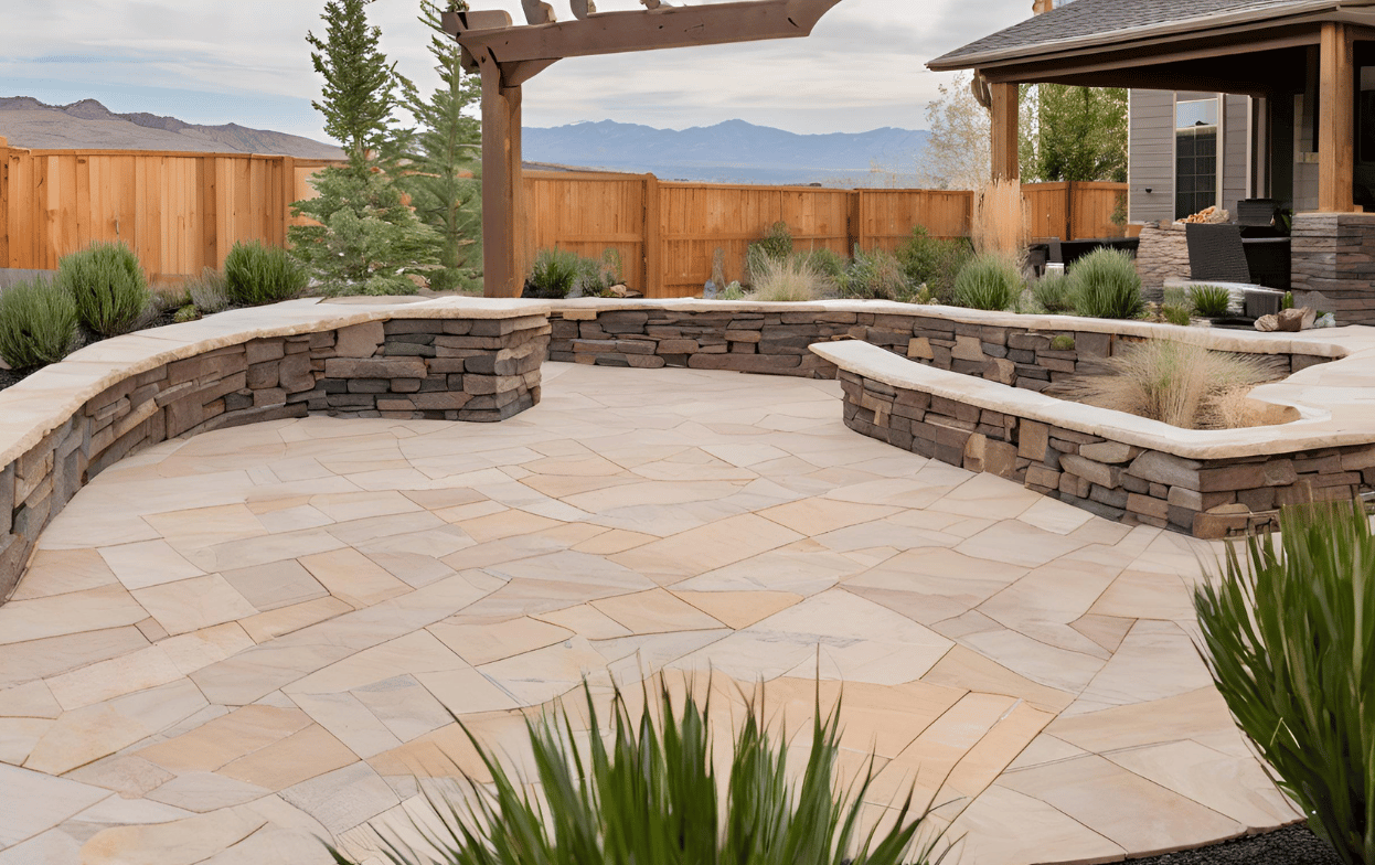 Stone patio with stone and wood retaining walls, wooden pergola, and landscaping. Mountain view in background.