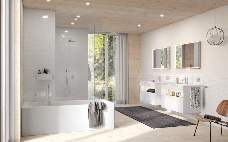 Modern white bathroom with tub, shower, and double vanity. Large window with outdoor view.