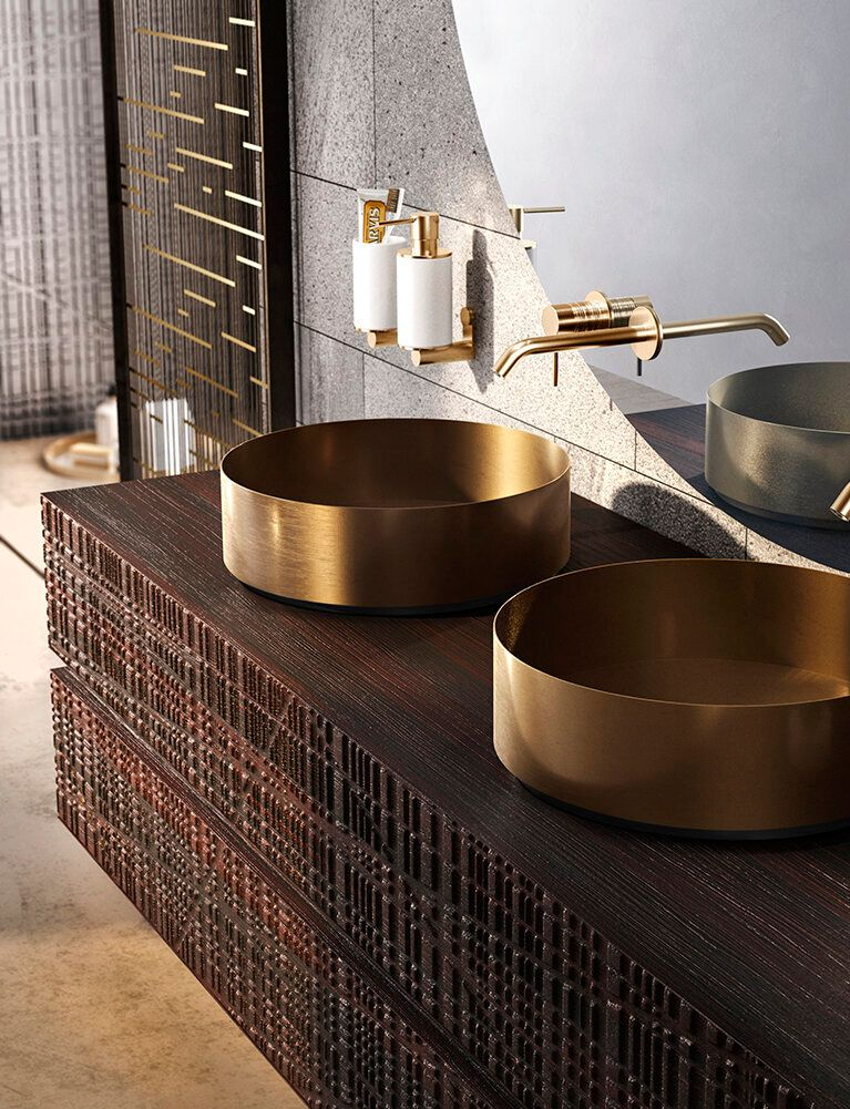Bathroom vanity with brass sinks, fixtures, and dark wood cabinetry.