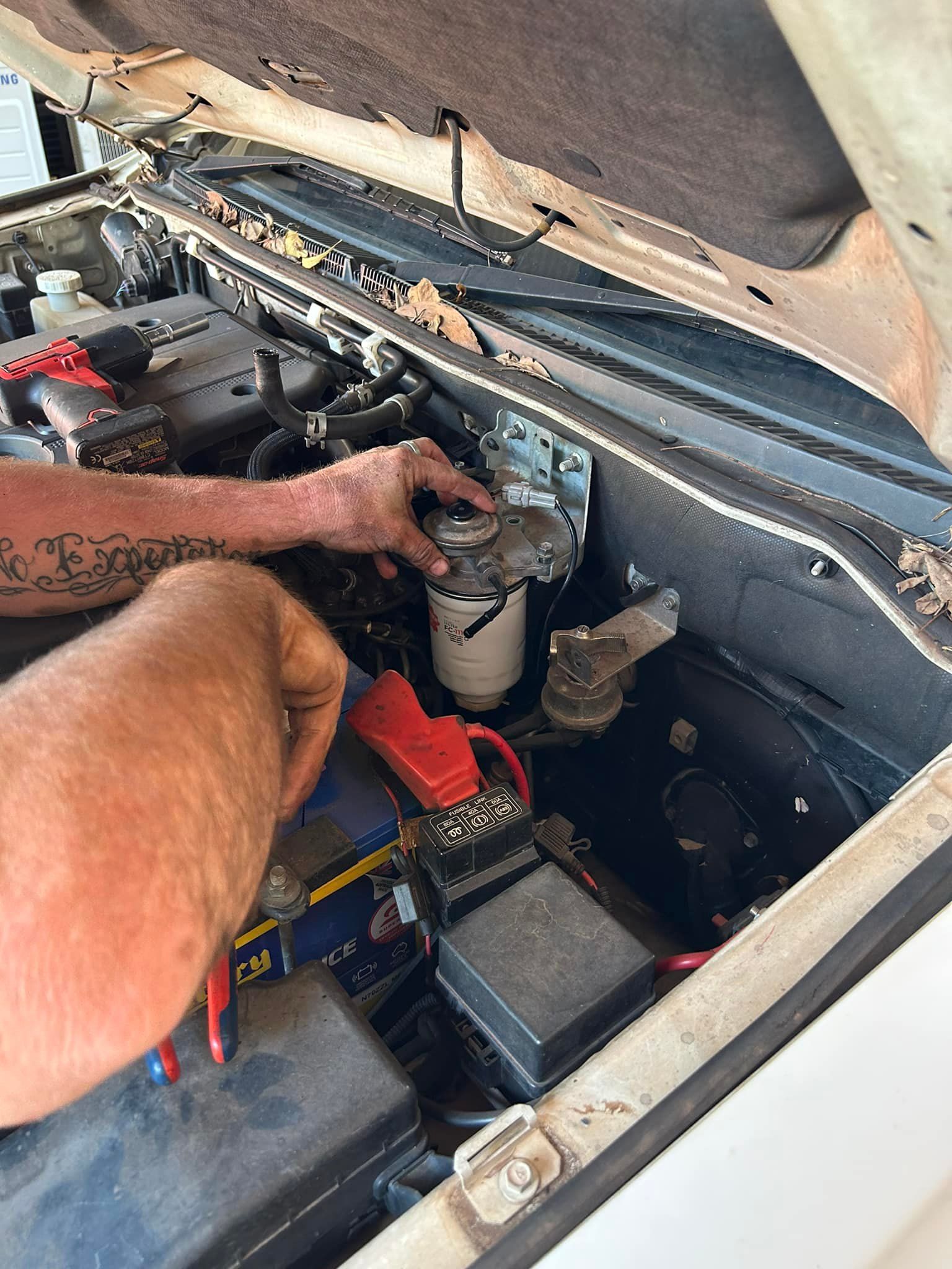 Man Working on Car Engine, Red Cables Attached to Battery — Mudpig Mechanical In Humpty Doo, NT