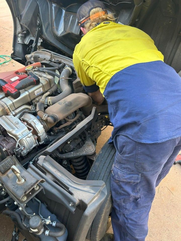 Mechanic Working on a Truck Engine, Wearing Yellow — Mudpig Mechanical In Humpty Doo, NT