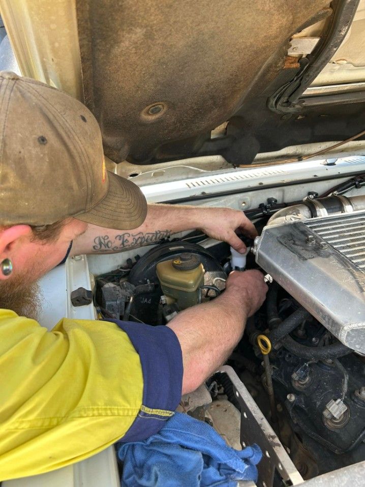 Mechanic Wearing And Yellow Shirt Working on a Car Engine — Mudpig Mechanical In Humpty Doo, NT