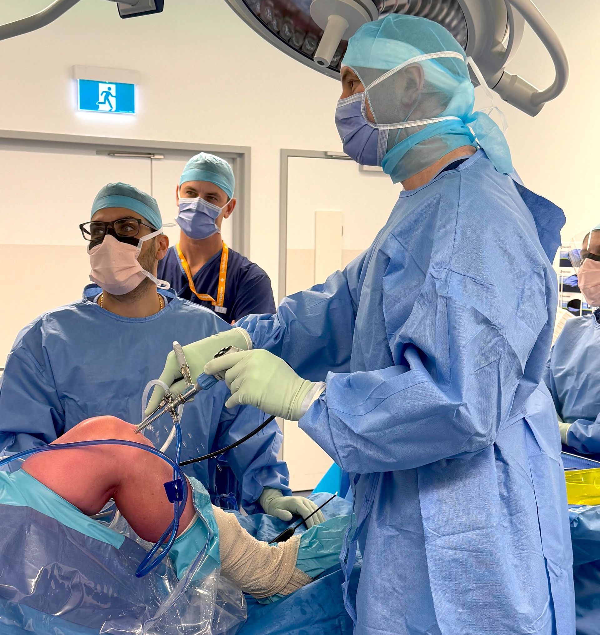 A group of surgeons are performing surgery in an operating room