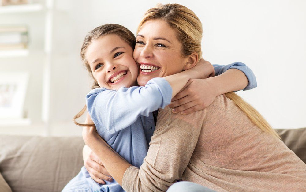 a mother and daughter hugging each other