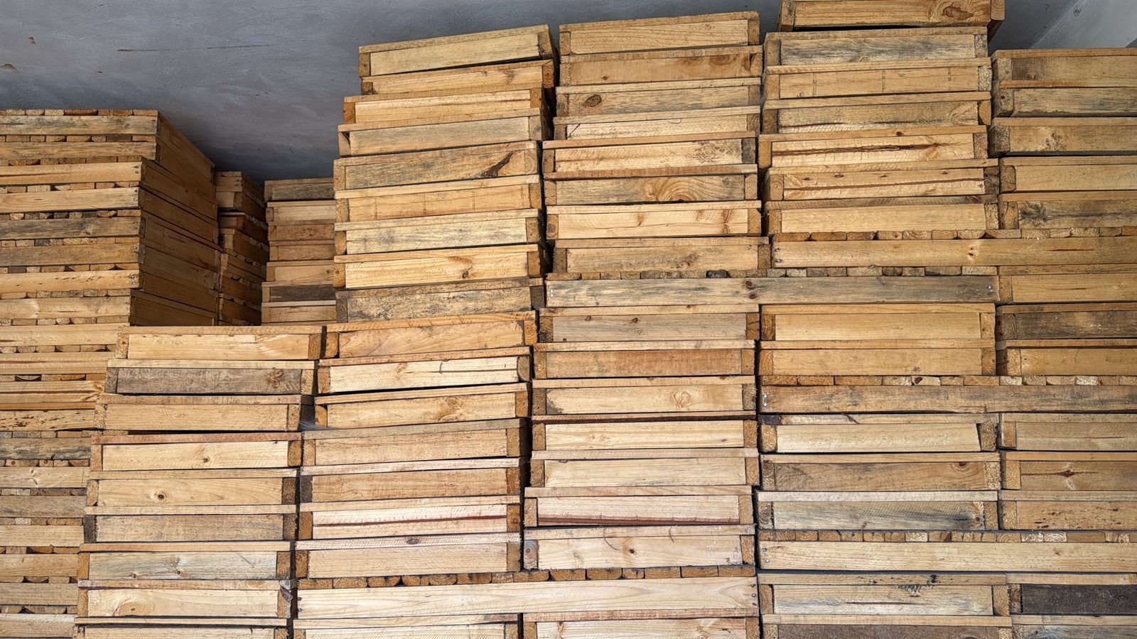 Una pila de paletas de madera están apiladas una encima de otra en una habitación.