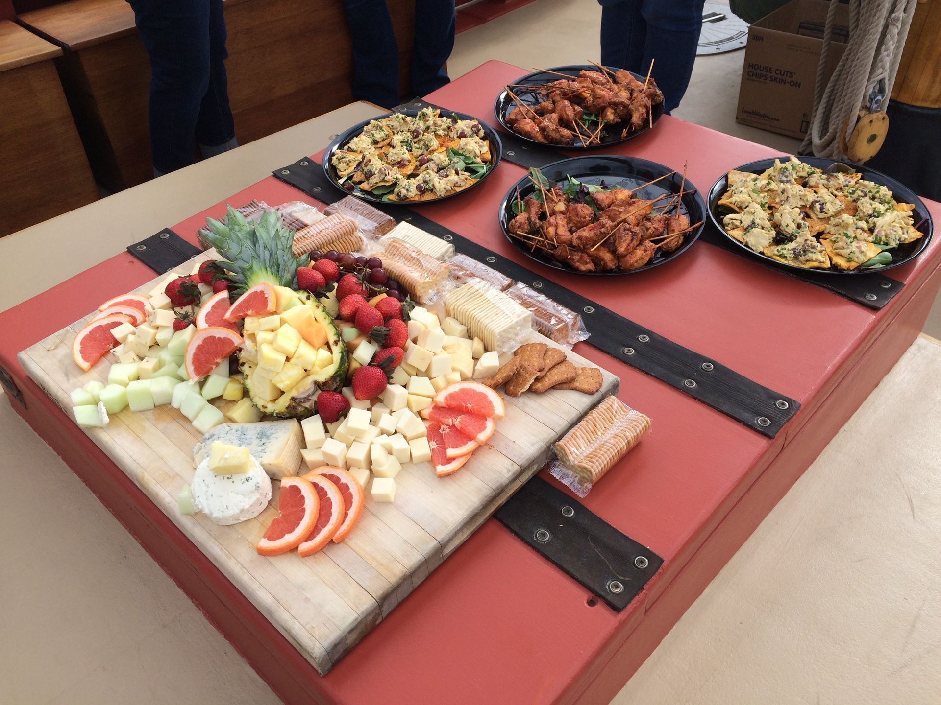 A table with plates of food and a cutting board with fruit on it