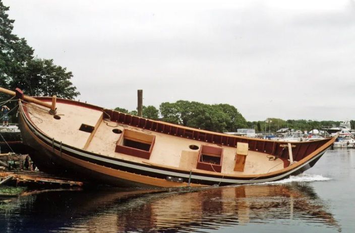 A boat is laying on its side in the water