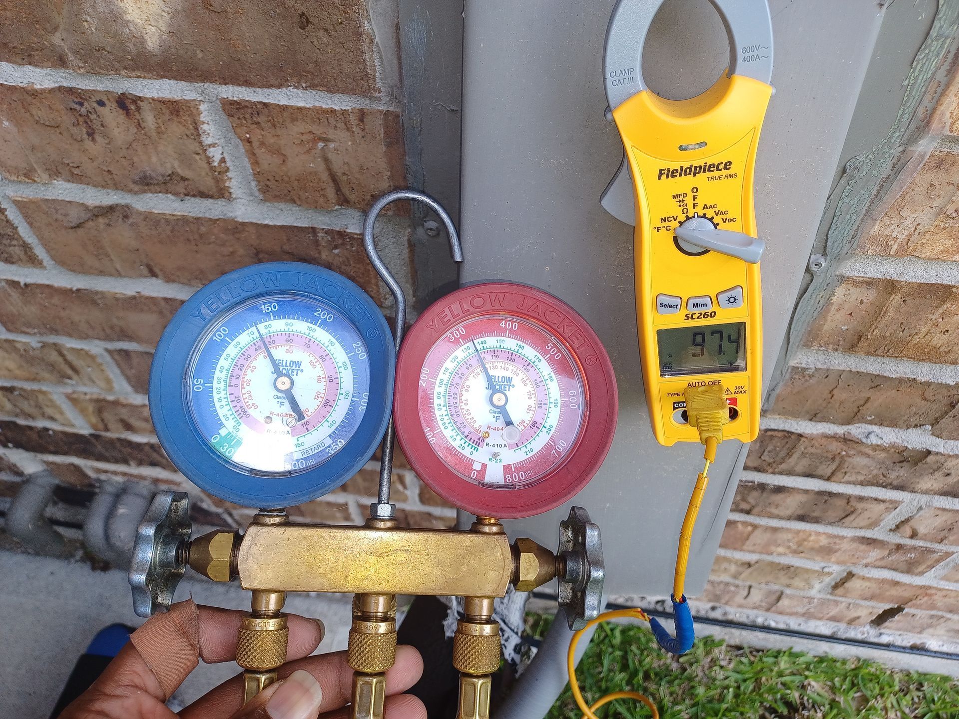 HVAC refrigerant gauges and Fieldpiece meter during AC replacement service by Arnett Mechanical