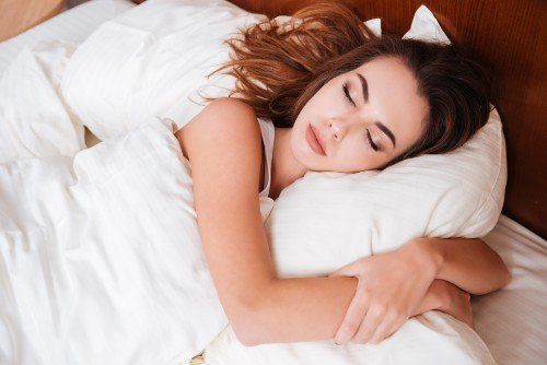 Giovane donna  dorme abbracciata  al suo cuscino