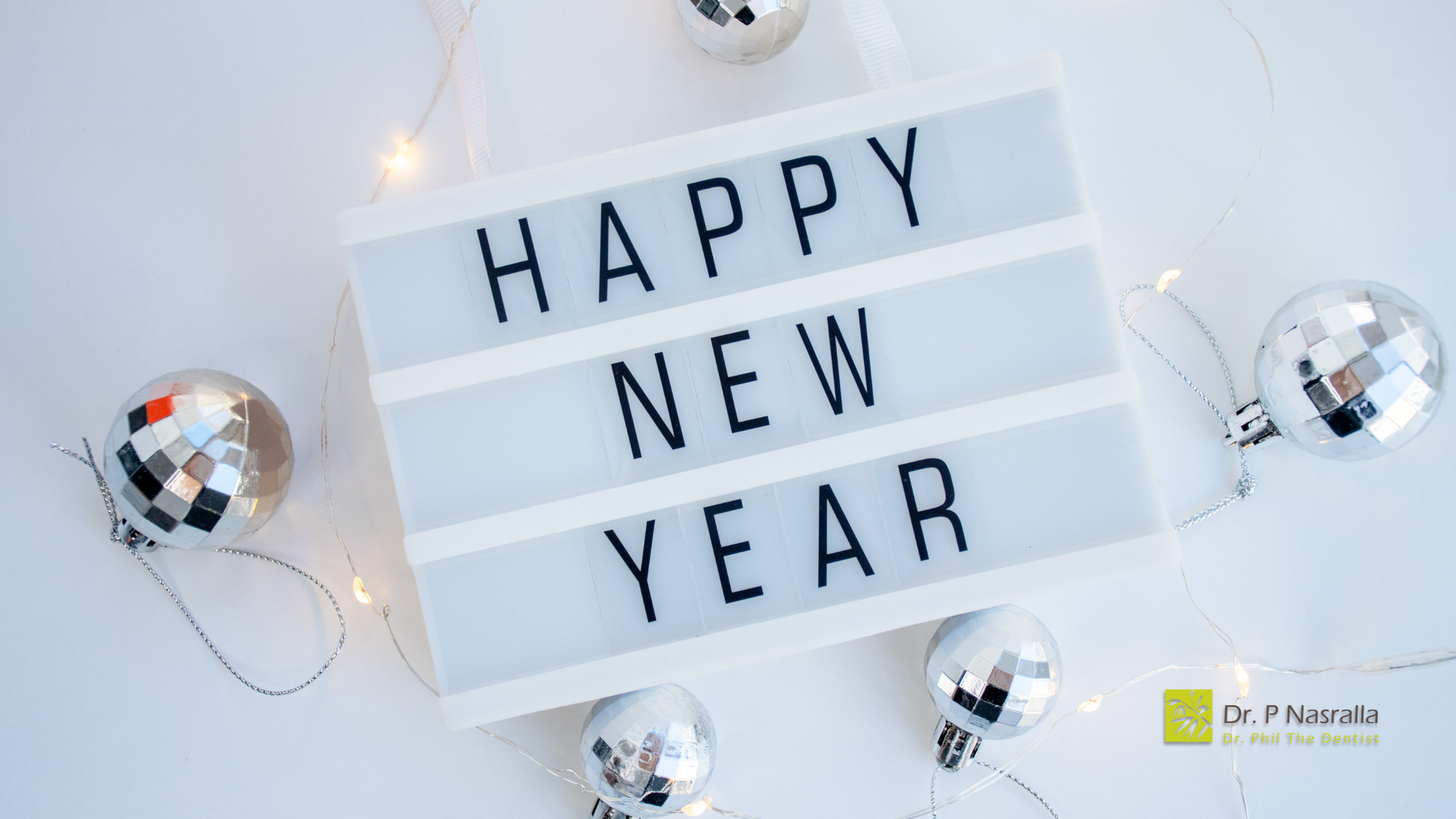 A sign that says `` happy new year '' is surrounded by christmas decorations.