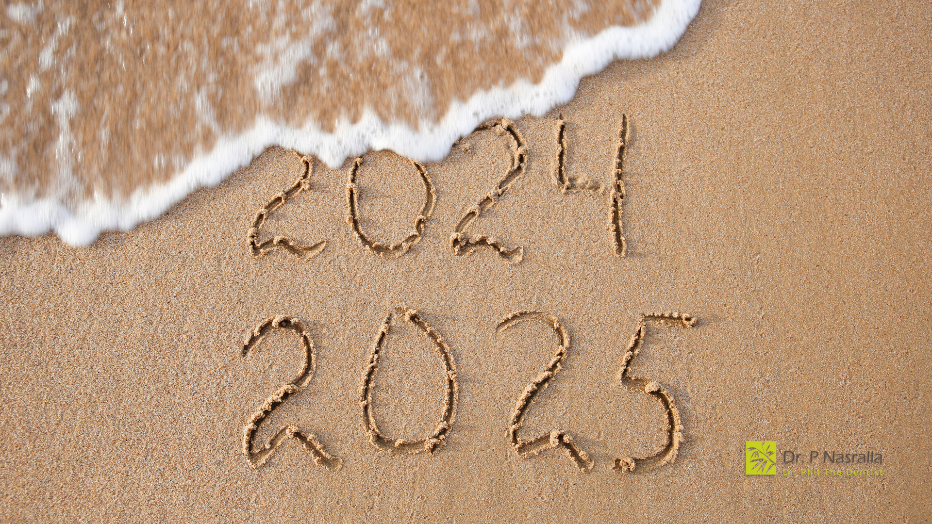 The year 2025 is written in the sand on the beach.