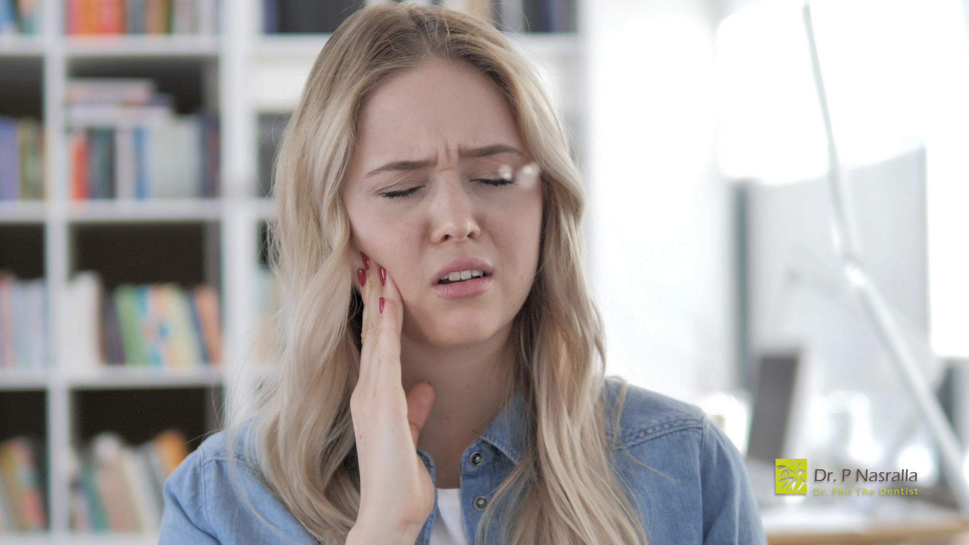 A woman is holding her face in pain because of a toothache.